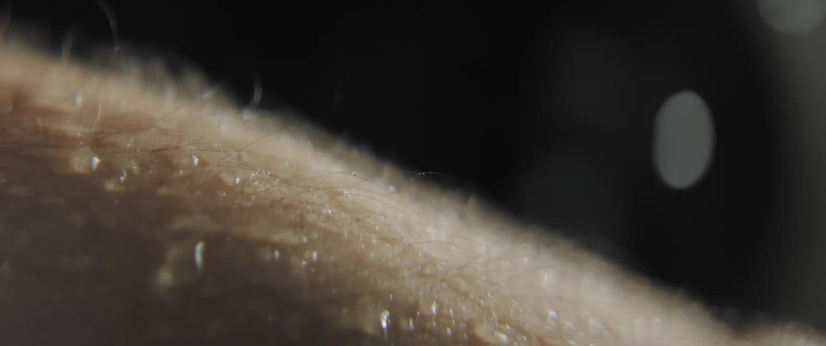 Water beads down a mans forearm