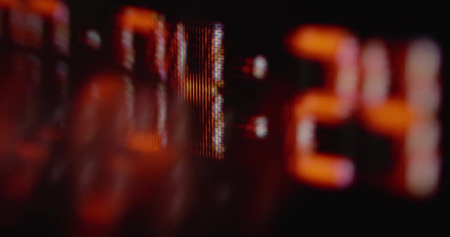 Macro shot of fast pixelated time code in red with black background on flickering vintage tube TV screen