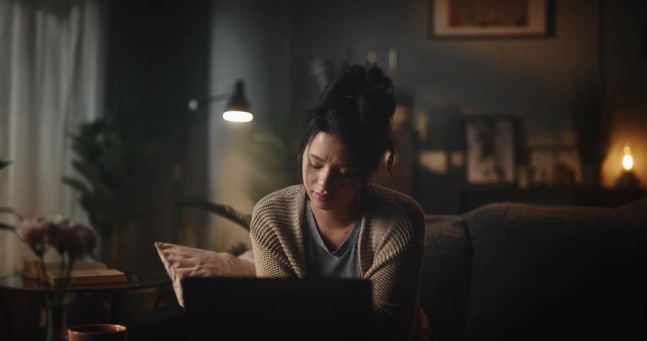 A woman speaks to someone using her laptop in her home