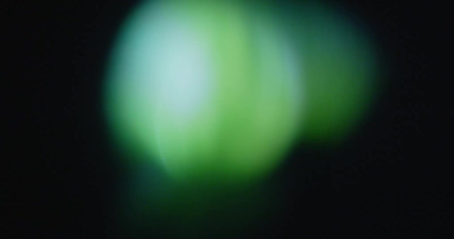 Digitized pixelated green watermelon spinning with black background on retro television screen with transformation