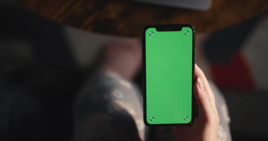 Woman sitting on couch uses smartphone