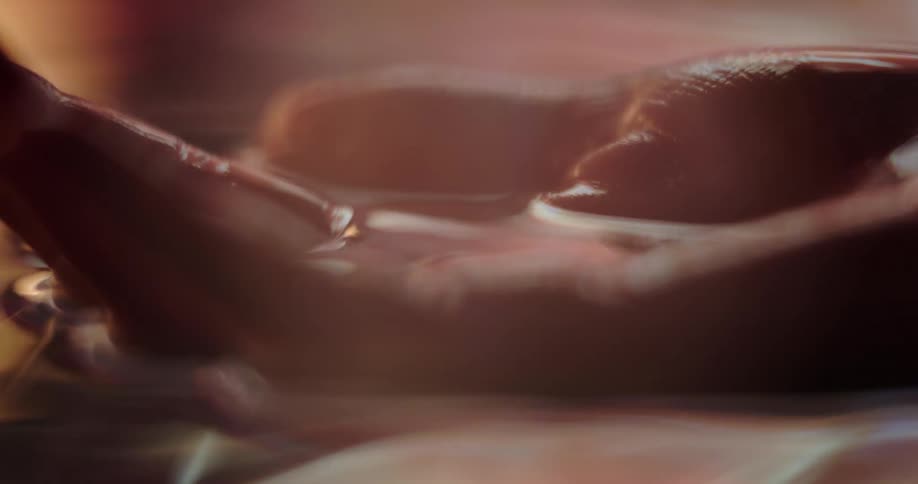 Light reflects on the water as a woman hold her hand underwater and holding water in the palm of her hand