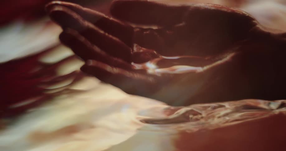 The hand submerges underwater