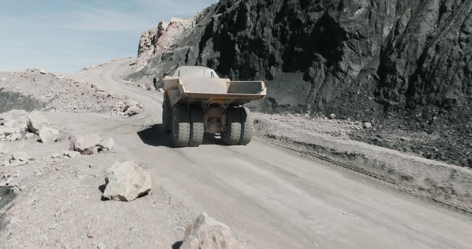 The dump truck is driving up the mountain