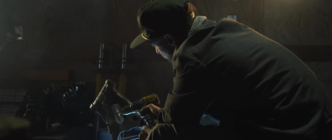 Close up of a mechanic using a handheld power tool to brush a car part