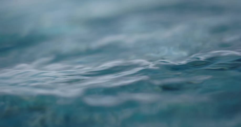 Close up of small ripples and waves on the surface of a body of clear water