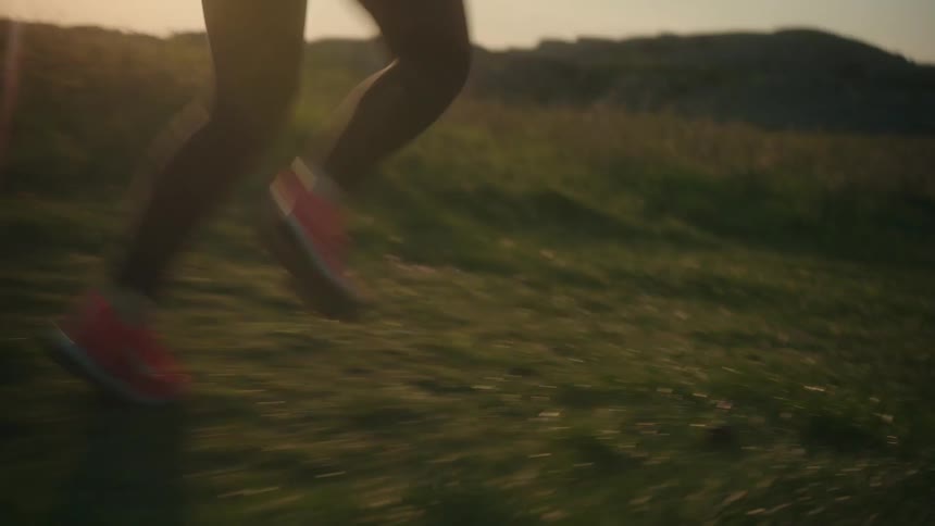 A woman is jogging through the grass