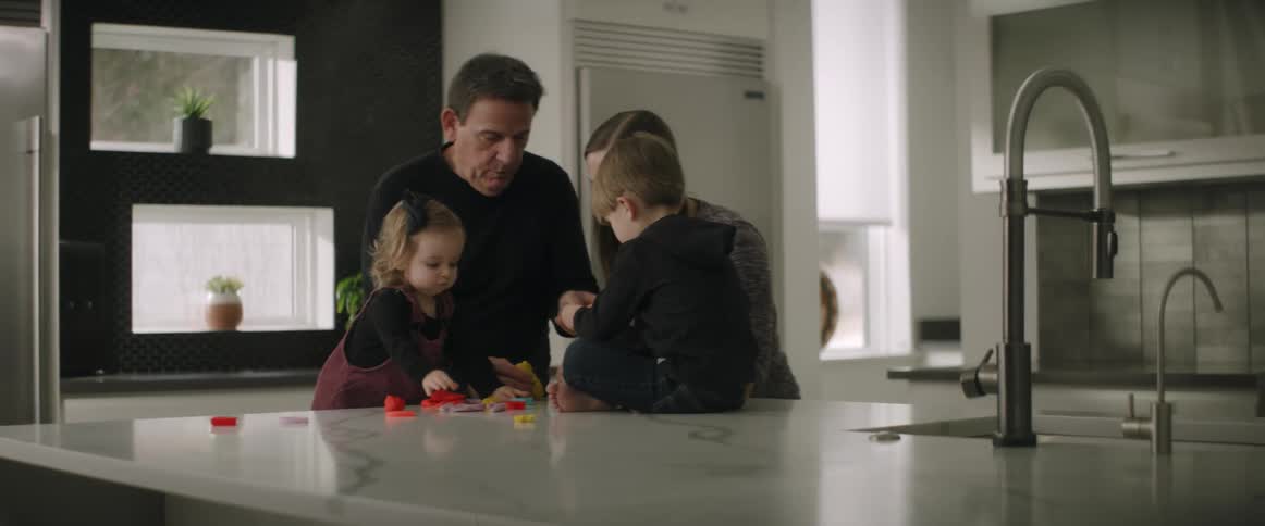 Parents playing with their kids on the kitchen countertop at home