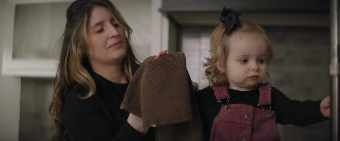 A woman wipes her daughters hands with a washcloth