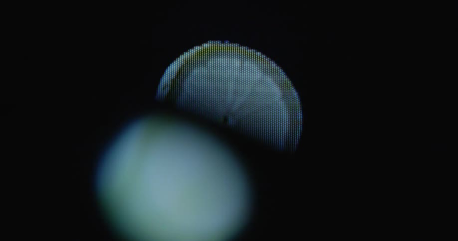 Digitalized 3d lemon slice with dripping juice turning in front of black background on old computer screen