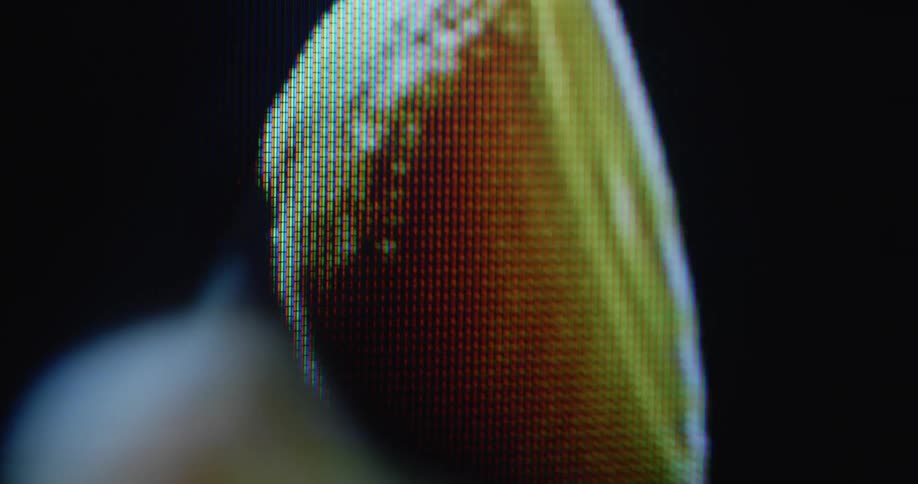 Dynamic close up of orange half rotating on flickering retro computer screen with lens flare and transformation