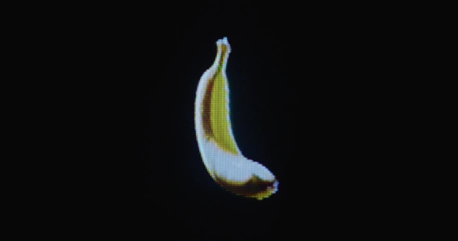 Close up of digitized turning organic banana fruit on glitching vintage tube TV with pixels