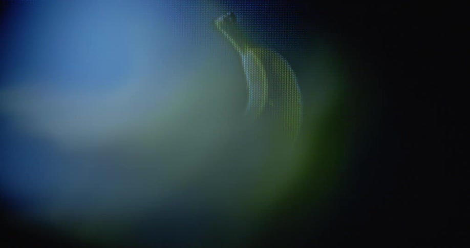 Pixelated fresh yellow banana spins around with black background on old television screen with transformation