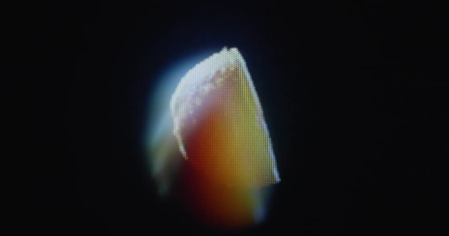 Pixelated digitized organic orange half spinning with black background on glitching vintage tube television