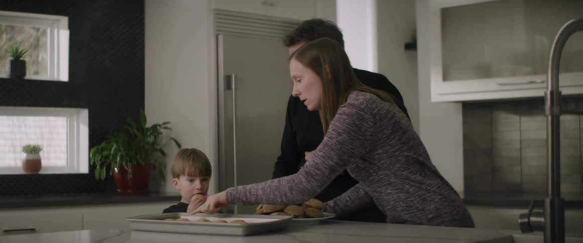 A family eats freshly baked cookies at home