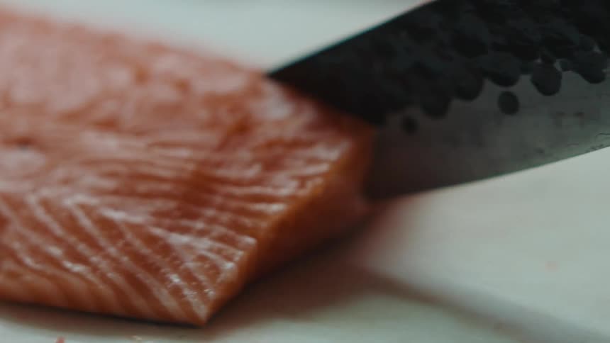 A person cuts a piece of fish