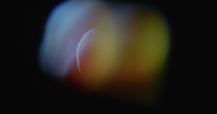 Digitalized fresh organic orange spins around with black background on old television screen with transformation and RGB pixels