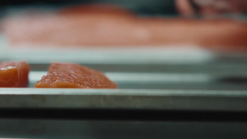 Woman puts fresh salmon steak in tray