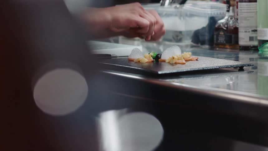 A chef is plating a meal