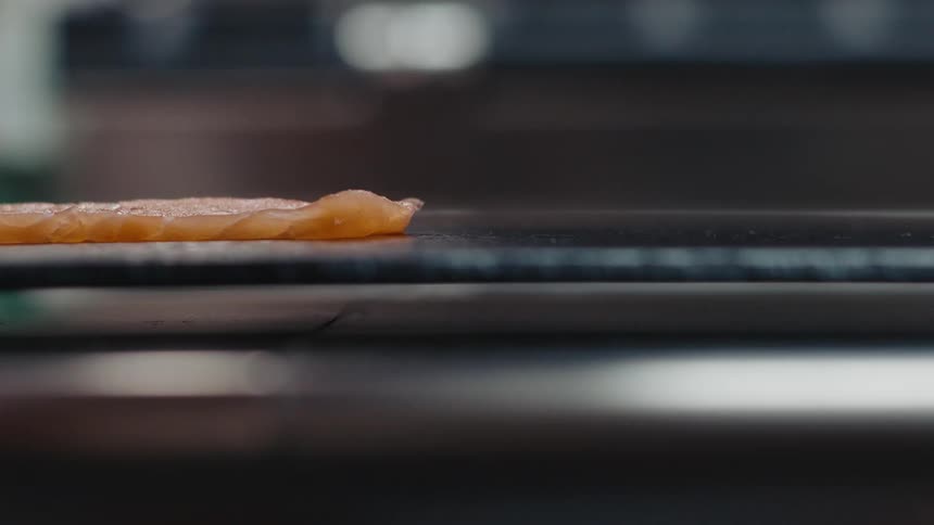 A person puts fish on a griddle to cook