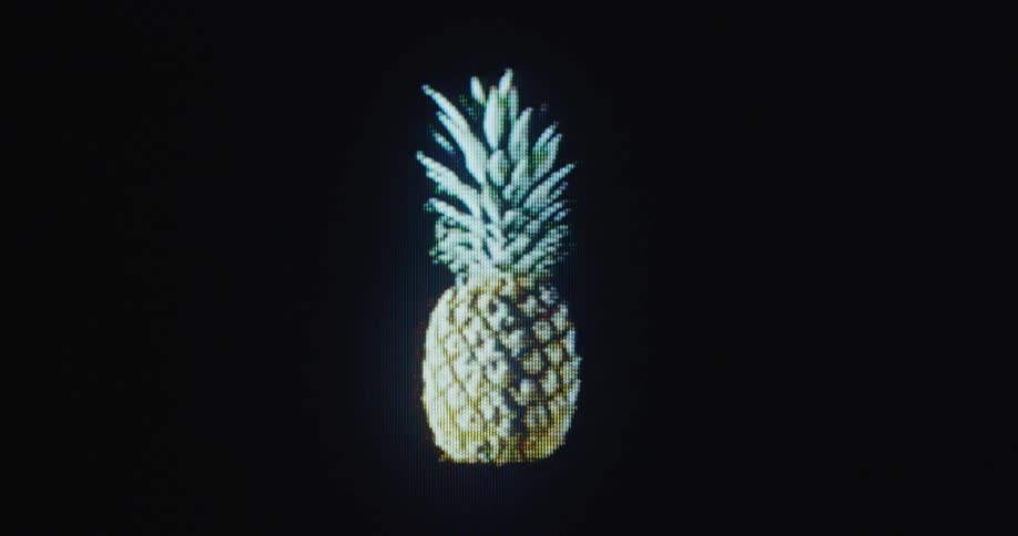 Close up of a pixelated floating spinning pineapple being transformed on flickering retro TV screen
