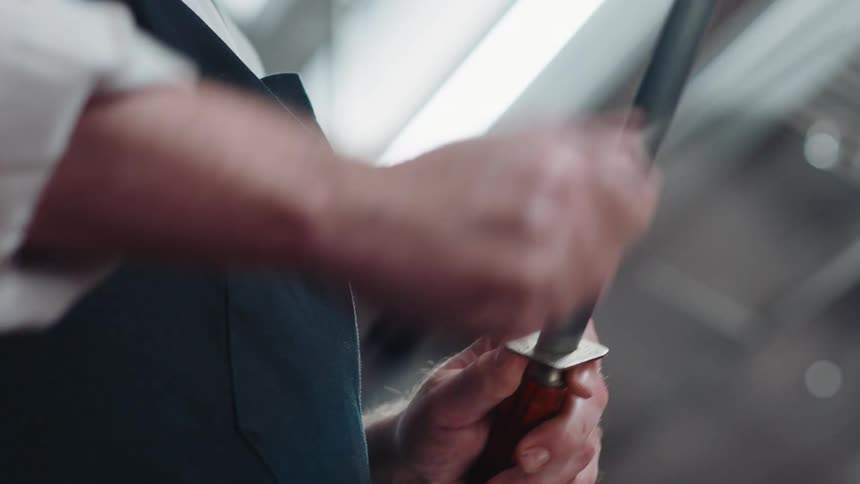 A chef is sharpening his knife