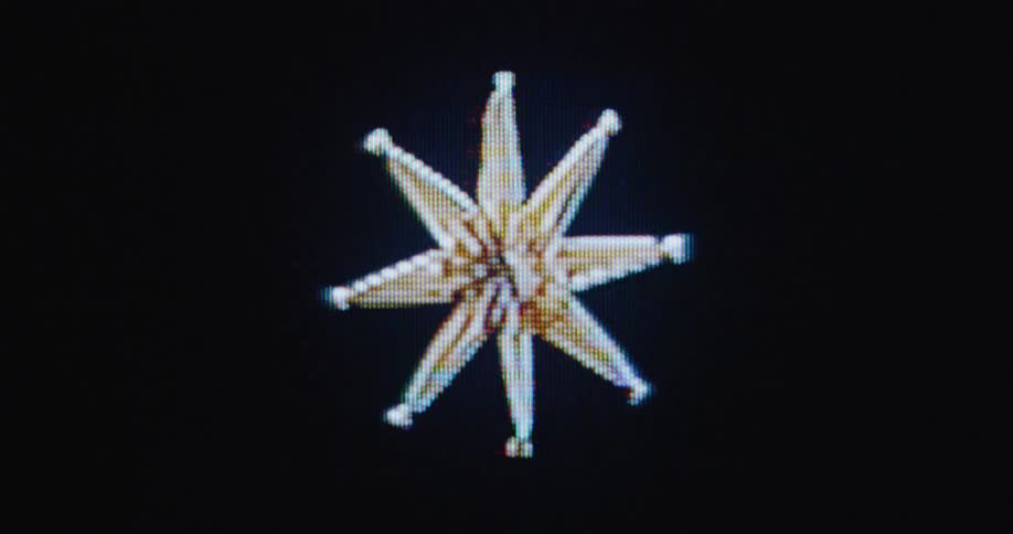 Close up of a pixelated straw star Christmas decoration ornament spinning on an old TV screen