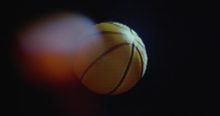 Close up of a pixelated basketball spinning and flying in the air on an old TV screen with glitches
