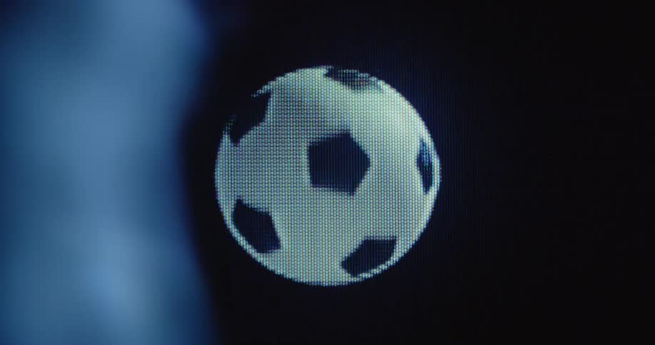 Macro shot of a pixelated black and white soccer ball that rotates on a black background on a vintage television screen