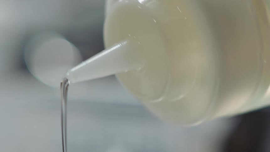 Close up of bottle with nozzle pouring