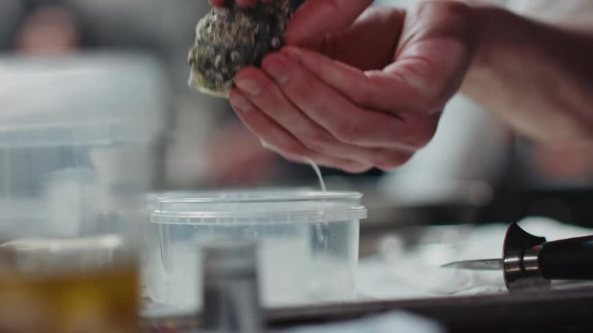 A person is shucking oysters