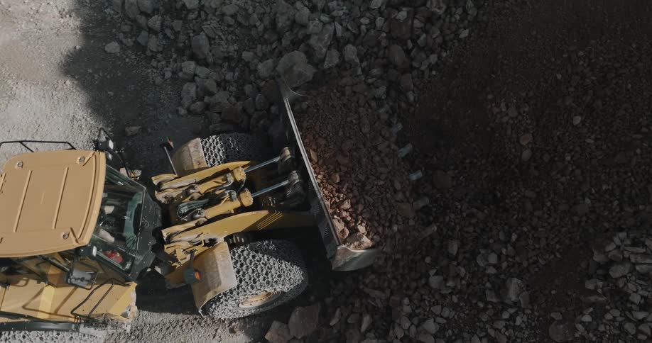 Aerial view of a bulldozer picking up gravel and dirt on a construction site