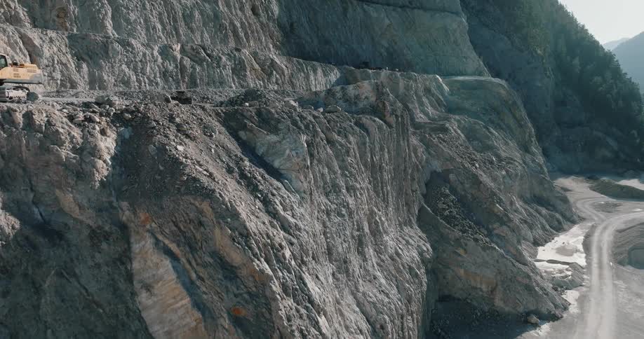An aerial view of a rocky mountain and dirt roads traveling throughout