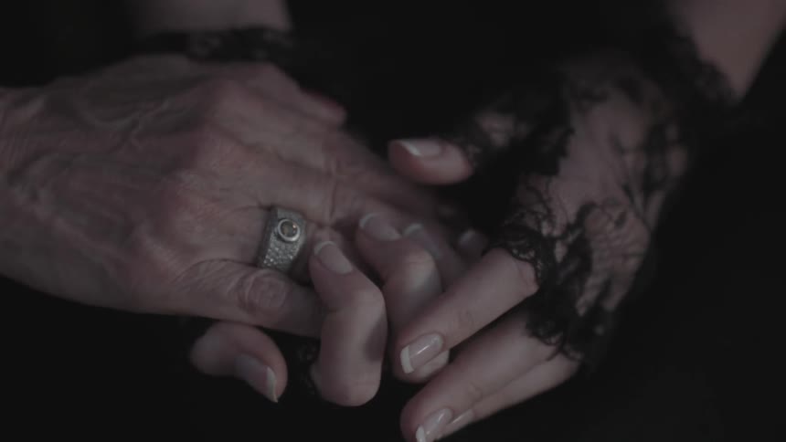 A woman holds hands with another person