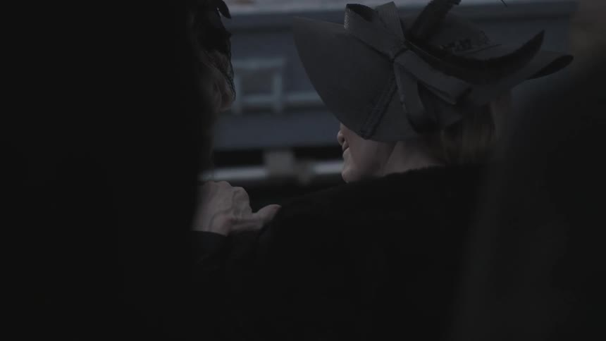 An older woman in black comforts another woman