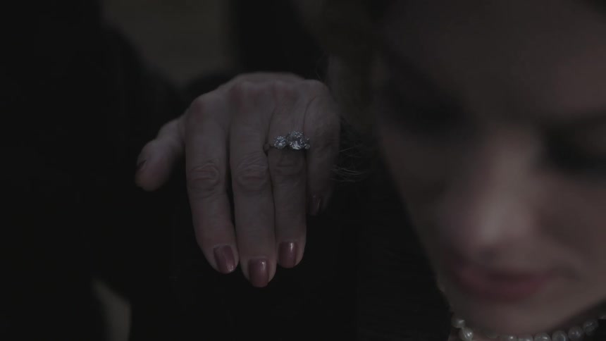 A person puts their hand on a woman's shoulder
