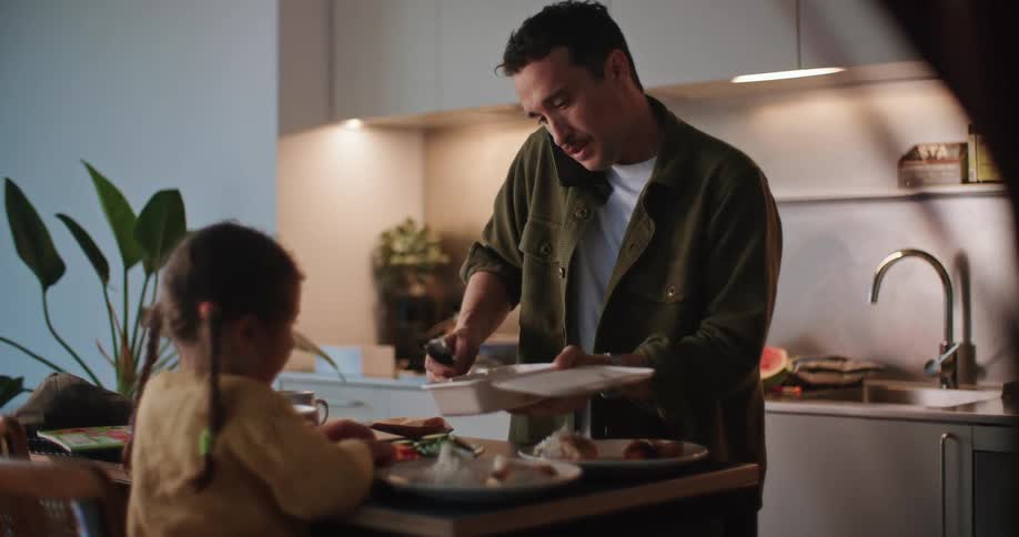 A man talks on his cell phone while eating food