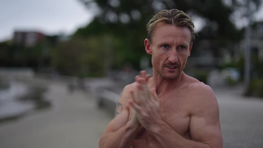 Swimmer on beach stretches and hopes before heading toward water
