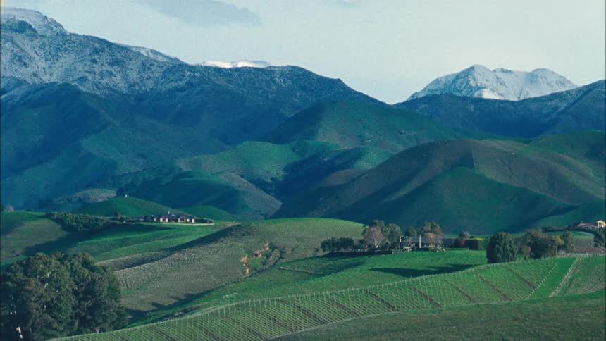 Landscape of village in hills in front of green mountains