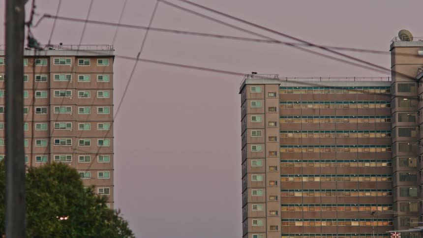 Two buildings across from each other with lots of windows against a cloudy sky