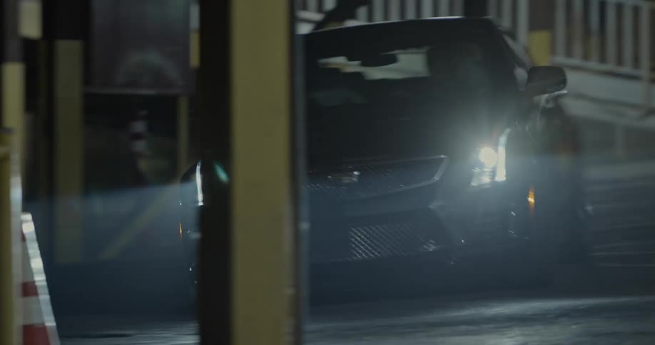 A car turning on a paved street at night
