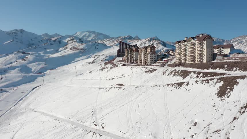 Aerial view of a large hotel complex on the snow covered slopes of a mountain range