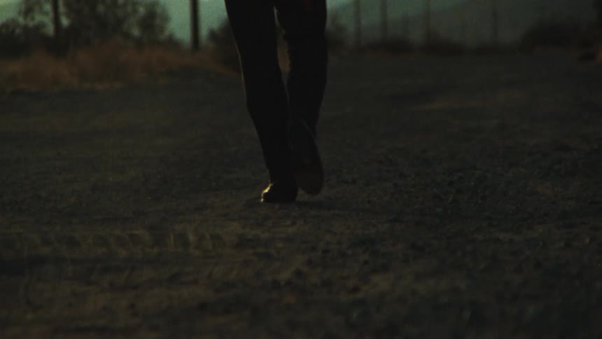 A man is walking outdoors in a rural area by himself