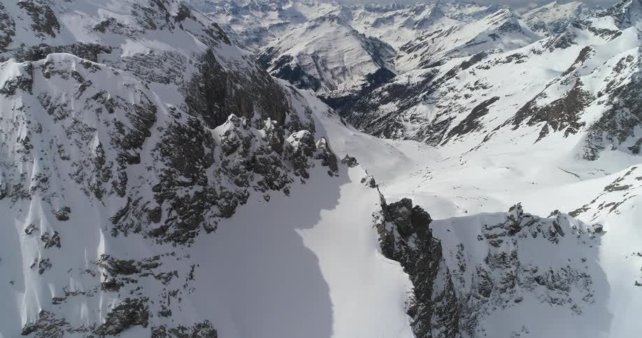 Aerial view of the snow covered slopes of a mountain range at daytime