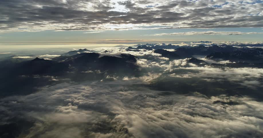 An aerial view of a mountain landscape with clouds settling over it