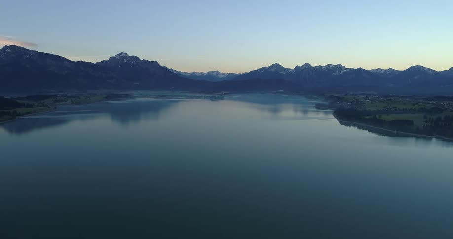 An aerial view of a lake with a mountainous background