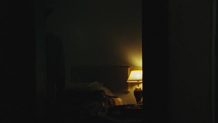 A man is walking around a room during the night time