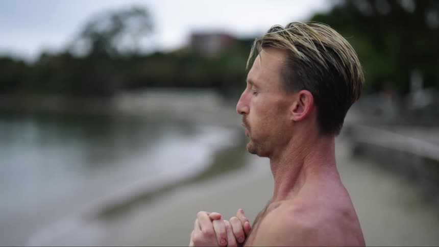 A man is standing on the coast of an ocean