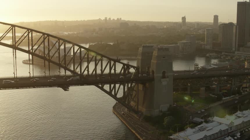 This impressive image showcases a massive bridge spanning over a body of sea water with cars moving along its lanes and a large ship visible in the water below