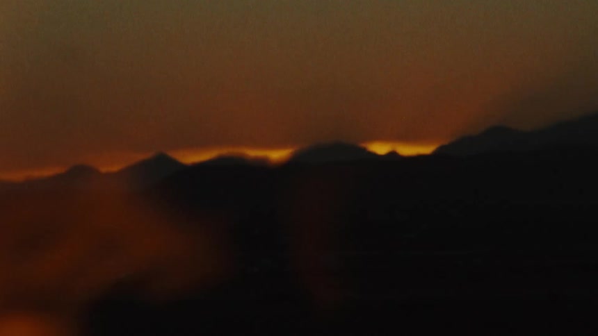An up close of a flame flickering against a silhouette background